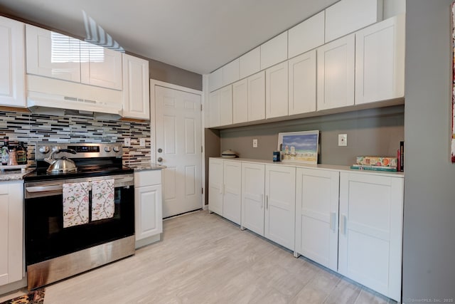 187 W Main St, East Lyme, CT 06357 - kitchen with stainless steel range with electric stovetop, under cabinet range hood, backsplash, white cabinets, and light wood-style floors