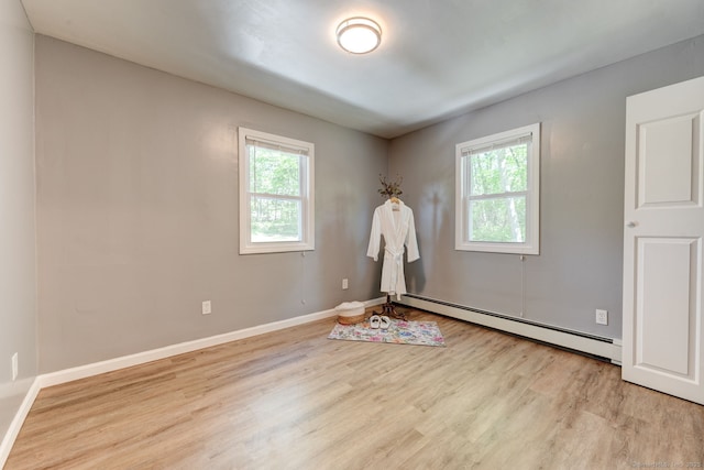 187 W Main St, East Lyme, CT 06357 - empty room featuring a baseboard heating unit, healthy amount of natural light, wood finished floors, and baseboards