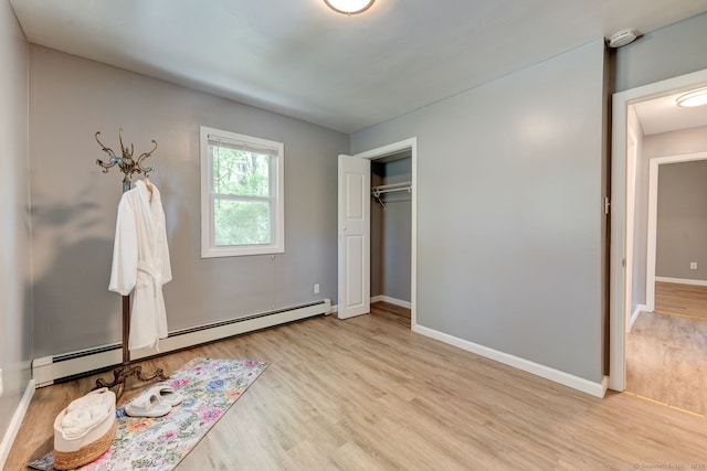 187 W Main St, East Lyme, CT 06357 - unfurnished bedroom with a baseboard heating unit, light wood finished floors, baseboards, and a closet