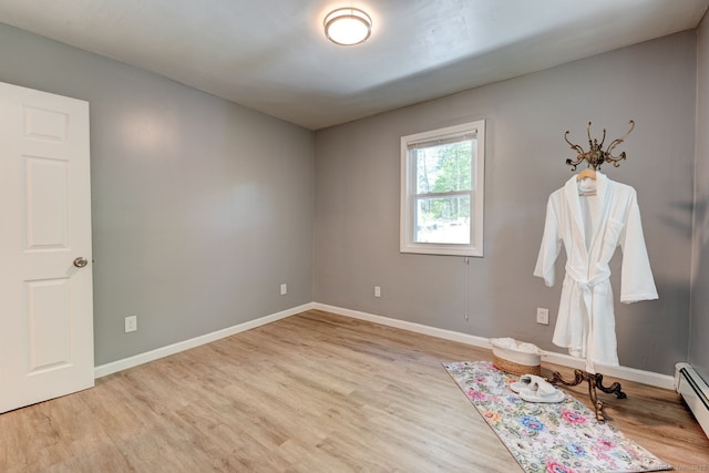 187 W Main St, East Lyme, CT 06357 - empty room with wood finished floors, baseboards, and a baseboard heating unit