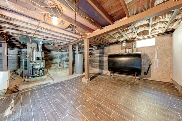 187 W Main St, East Lyme, CT 06357 - basement with oil tank, water heater, a heating unit, and wood finished floors