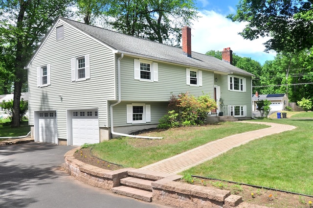 83 Elizabeth St, South Windsor, CT 06074 - raised ranch featuring driveway, a chimney, an attached garage, and a front lawn