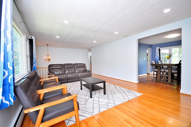 83 Elizabeth St, South Windsor, CT 06074 - living room with baseboard heating, a chandelier, light wood-style floors, recessed lighting, and baseboards