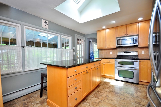 83 Elizabeth St, South Windsor, CT 06074 - kitchen featuring appliances with stainless steel finishes, a baseboard heating unit, a skylight, tasteful backsplash, and a kitchen island