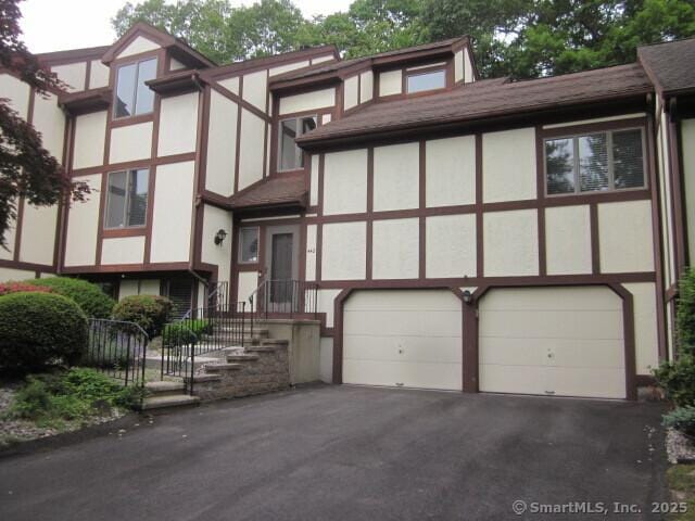 690 Forest Rd Unit 442, West Haven, CT 06516 - tudor home featuring an attached garage, stucco siding, and asphalt driveway