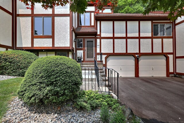 690 Forest Rd Unit 442, West Haven, CT 06516 - view of front facade featuring an attached garage, stucco siding, and driveway