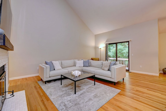 690 Forest Rd Unit 442, West Haven, CT 06516 - living area featuring high vaulted ceiling, light wood finished floors, a brick fireplace, and baseboards