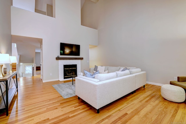 690 Forest Rd Unit 442, West Haven, CT 06516 - living room with light wood-style floors, baseboards, a fireplace, and a towering ceiling