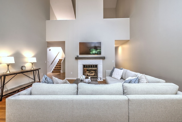 690 Forest Rd Unit 442, West Haven, CT 06516 - living room with wood finished floors, a brick fireplace, stairway, and a towering ceiling