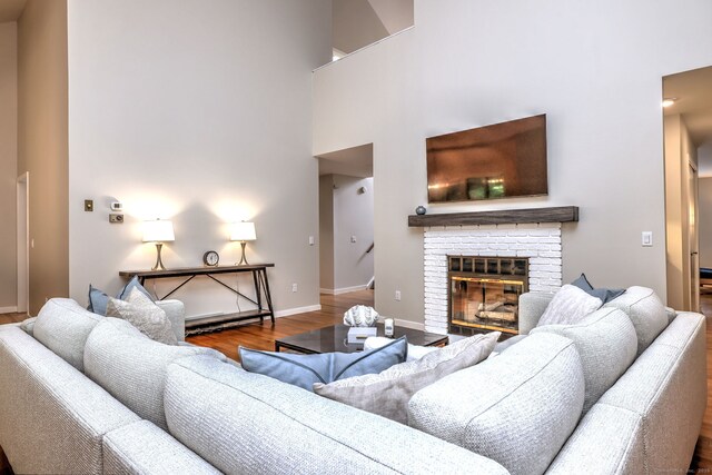 690 Forest Rd Unit 442, West Haven, CT 06516 - living area featuring wood finished floors, a fireplace, baseboards, and a high ceiling