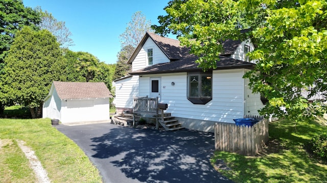 62 Pratt St, Norwich, CT 06360 - view of front facade with an outdoor structure, a front lawn, roof with shingles, and a garage