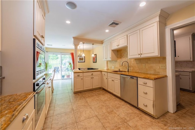 36 Old Johnson Ln, Middletown, CT 06457 - kitchen featuring appliances with stainless steel finishes, a sink, decorative backsplash, light stone countertops, and a peninsula