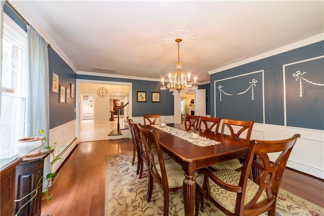 36 Old Johnson Ln, Middletown, CT 06457 - dining area featuring baseboard heating, a chandelier, ornamental molding, wood finished floors, and a wainscoted wall