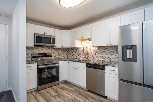 104 Oakwood Ave Apt T3, West Hartford, CT 06119 - kitchen with appliances with stainless steel finishes, a sink, dark stone countertops, and white cabinetry
