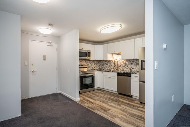 104 Oakwood Ave Apt T3, West Hartford, CT 06119 - kitchen featuring appliances with stainless steel finishes, tasteful backsplash, white cabinets, dark countertops, and wood finished floors