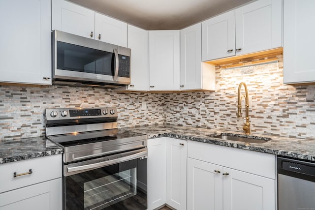 104 Oakwood Ave Apt T3, West Hartford, CT 06119 - kitchen with appliances with stainless steel finishes, a sink, white cabinetry, dark stone countertops, and backsplash