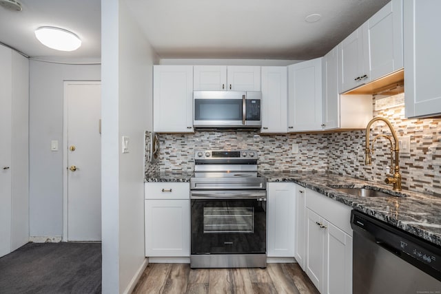 104 Oakwood Ave Apt T3, West Hartford, CT 06119 - kitchen featuring stainless steel appliances, a sink, white cabinets, dark stone countertops, and decorative backsplash