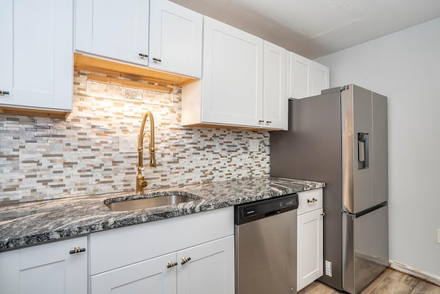 104 Oakwood Ave Apt T3, West Hartford, CT 06119 - kitchen with stainless steel appliances, a sink, white cabinetry, dark stone counters, and decorative backsplash