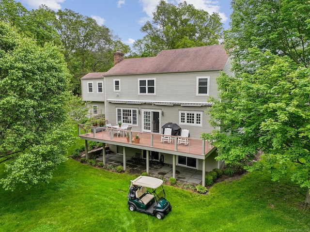 15 Silvermine Woods Rd Unit 15, Wilton, CT 06897 - rear view of property featuring a deck, a chimney, a lawn, a patio area, and roof with shingles