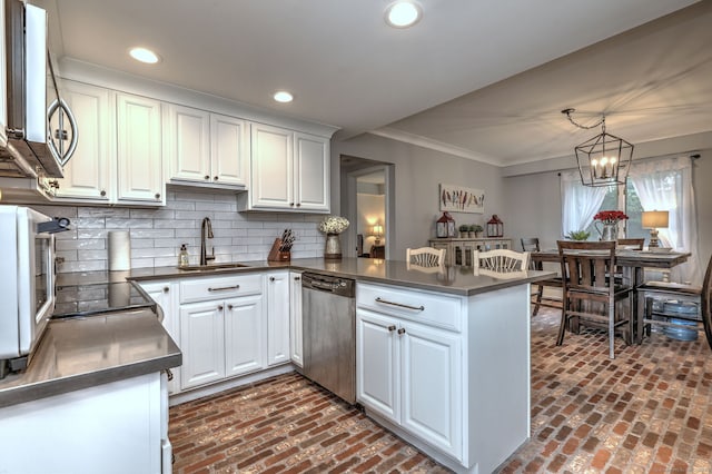 714 Popes Island Rd Unit 714, Milford, CT 06461 - kitchen with appliances with stainless steel finishes, a sink, brick flooring, dark countertops, and crown molding