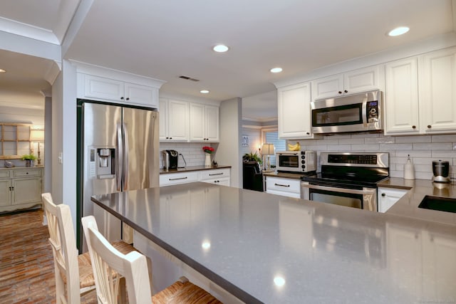 714 Popes Island Rd Unit 714, Milford, CT 06461 - kitchen with appliances with stainless steel finishes, white cabinetry, tasteful backsplash, dark countertops, and recessed lighting