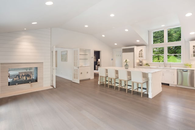 50 Parish Rd N, New Canaan, CT 06840 - kitchen with stainless steel dishwasher, a kitchen island, a kitchen bar, lofted ceiling, and white cabinets
