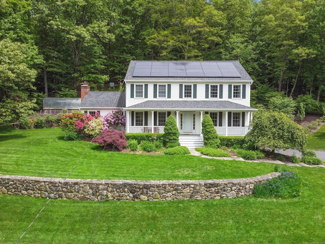 22 Gelding Hill Rd, Newtown, CT 06482 - view of front facade featuring solar panels, covered porch, a wooded view, and a front lawn