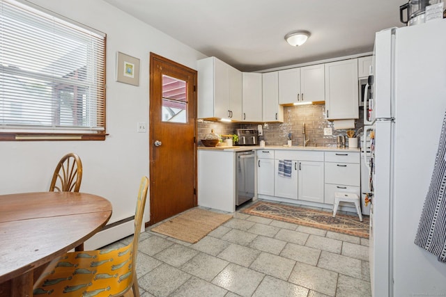 64 Willow St, Milford, CT 06460 - kitchen with freestanding refrigerator, stainless steel dishwasher, decorative backsplash, light countertops, and white cabinets