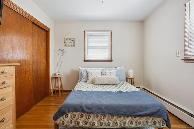 64 Willow St, Milford, CT 06460 - bedroom with a baseboard heating unit, wood finished floors, and a closet