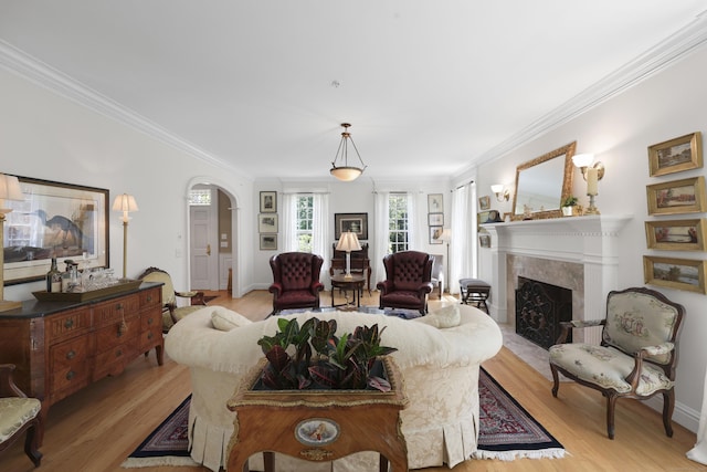 52 Dug Rd, Glastonbury, CT 06073 - living room with ornamental molding, light wood-style floors, a premium fireplace, arched walkways, and baseboards