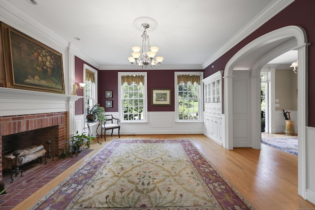 52 Dug Rd, Glastonbury, CT 06073 - foyer entrance with a chandelier, light wood finished floors, crown molding, a wainscoted wall, and a fireplace