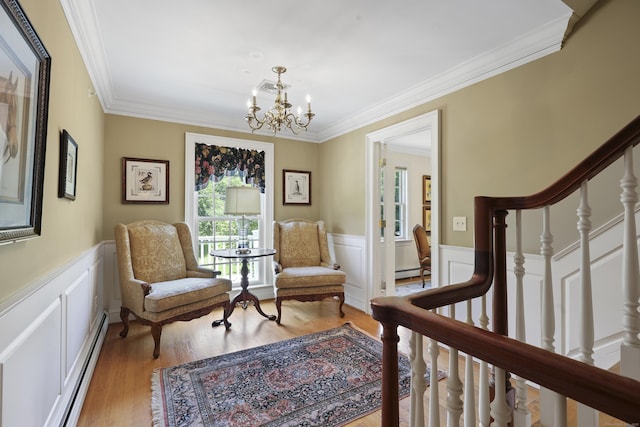 52 Dug Rd, Glastonbury, CT 06073 - living area with a wainscoted wall, ornamental molding, a chandelier, light wood-style floors, and a decorative wall