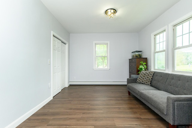 163 State Ave, Killingly, CT 06241 - living area with a baseboard heating unit, healthy amount of natural light, and dark wood-type flooring