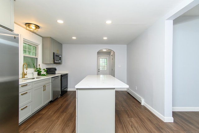 163 State Ave, Killingly, CT 06241 - kitchen with baseboard heating, appliances with stainless steel finishes, a center island, arched walkways, and gray cabinets