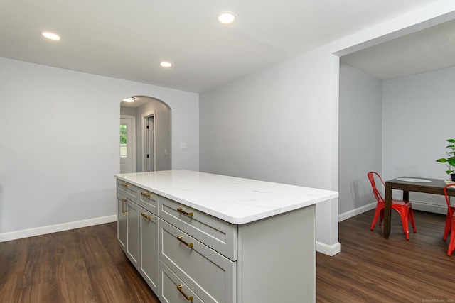 163 State Ave, Killingly, CT 06241 - kitchen featuring gray cabinets, arched walkways, dark wood finished floors, light stone countertops, and recessed lighting