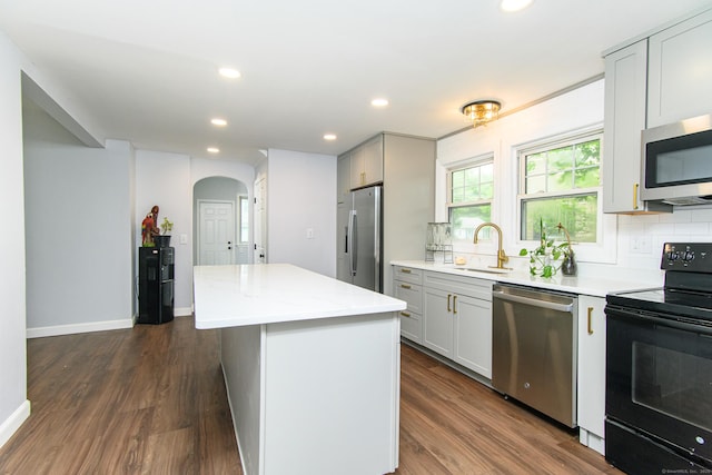 163 State Ave, Killingly, CT 06241 - kitchen with appliances with stainless steel finishes, arched walkways, decorative backsplash, a kitchen island, and recessed lighting