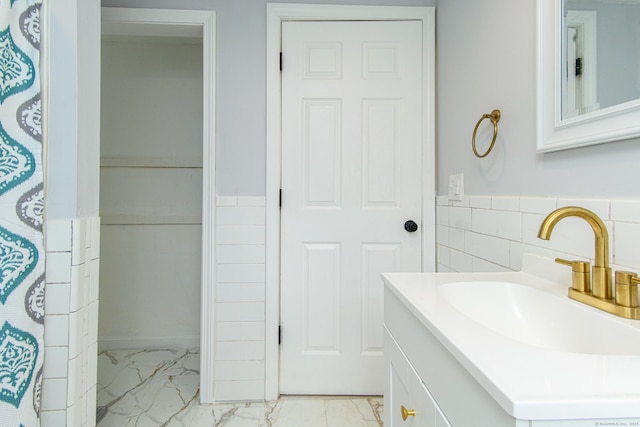 163 State Ave, Killingly, CT 06241 - full bathroom with marble finish floors, tile walls, vanity, and wainscoting