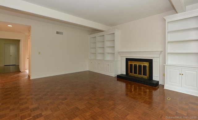 881 Heritage Vlg Unit B, Southbury, CT 06488 - unfurnished living room featuring built in features, baseboards, a glass covered fireplace, beam ceiling, and recessed lighting