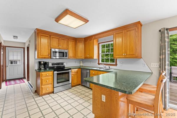 5 Conrad Ct, Ledyard, CT 06335 - kitchen with stainless steel appliances, baseboard heating, healthy amount of natural light, and dark countertops