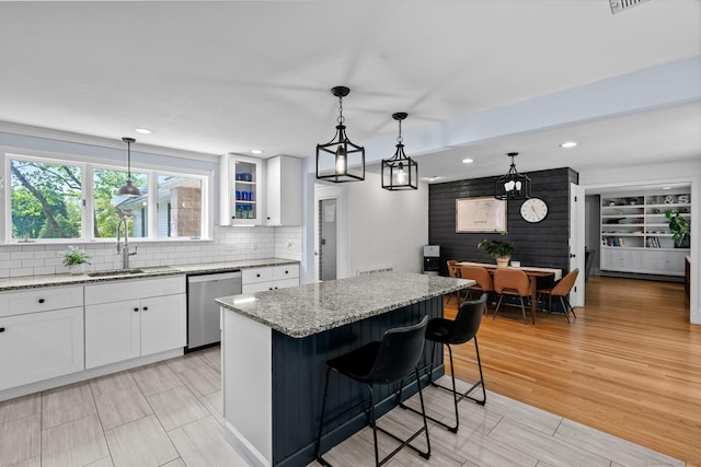 401 Russell Ave, Suffield, CT 06078 - kitchen with stainless steel dishwasher, a sink, white cabinets, light stone countertops, and recessed lighting