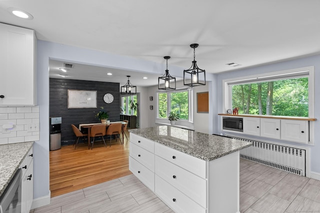 401 Russell Ave, Suffield, CT 06078 - kitchen featuring built in microwave, wood finish floors, recessed lighting, white cabinetry, and a center island