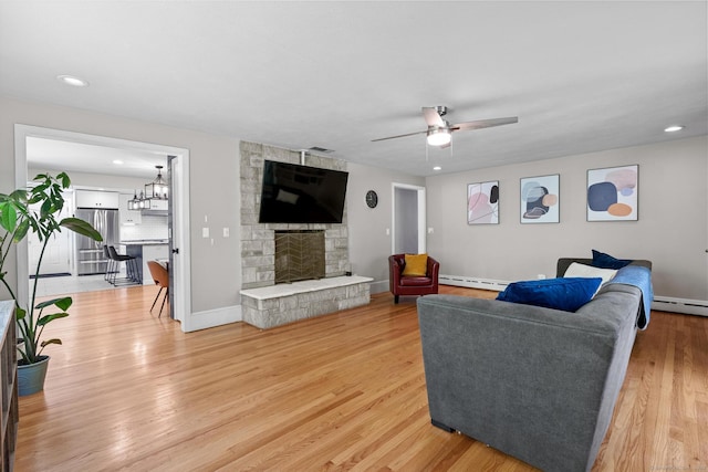 401 Russell Ave, Suffield, CT 06078 - living area featuring a baseboard radiator, a ceiling fan, light wood finished floors, a fireplace, and baseboards