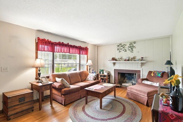 47 Varno Ln, Enfield, CT 06082 - living area with wood finished floors, a brick fireplace, and a textured ceiling