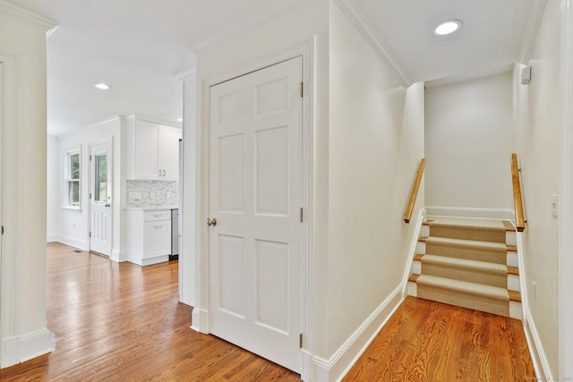 50 Harrison Ave, New Canaan, CT 06840 - hall with light wood finished floors, crown molding, baseboards, recessed lighting, and stairs