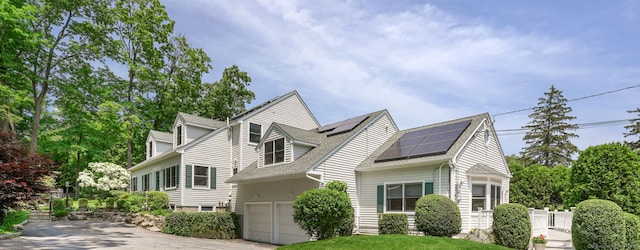 50 Harrison Ave, New Canaan, CT 06840 - view of front of home with driveway, solar panels, and roof with shingles