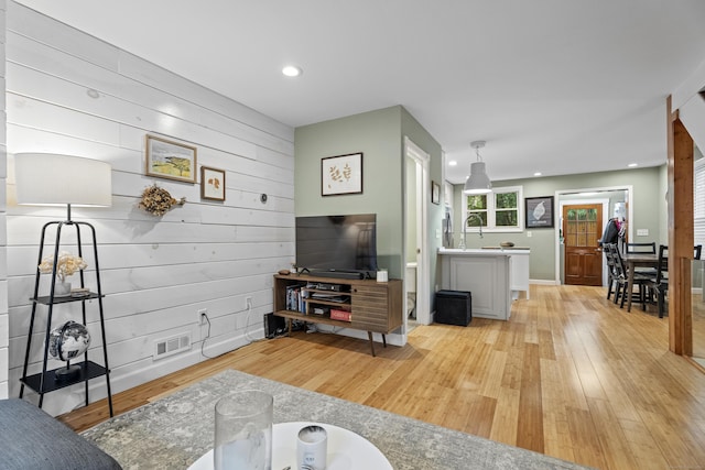 128 Mill River St, New Haven, CT 06511 - living area with light wood-style floors, recessed lighting, and wooden walls
