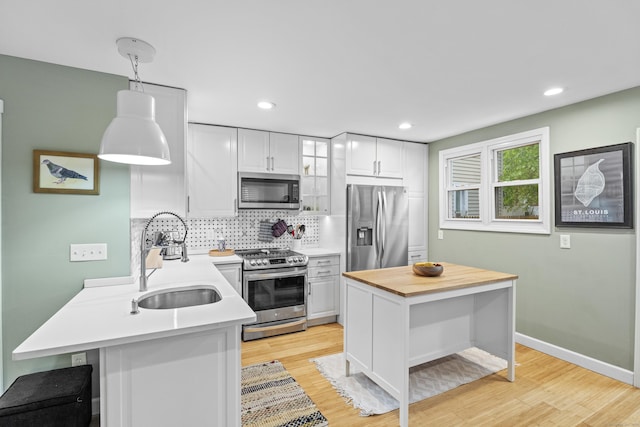 128 Mill River St, New Haven, CT 06511 - kitchen with appliances with stainless steel finishes, a sink, butcher block counters, tasteful backsplash, and white cabinets