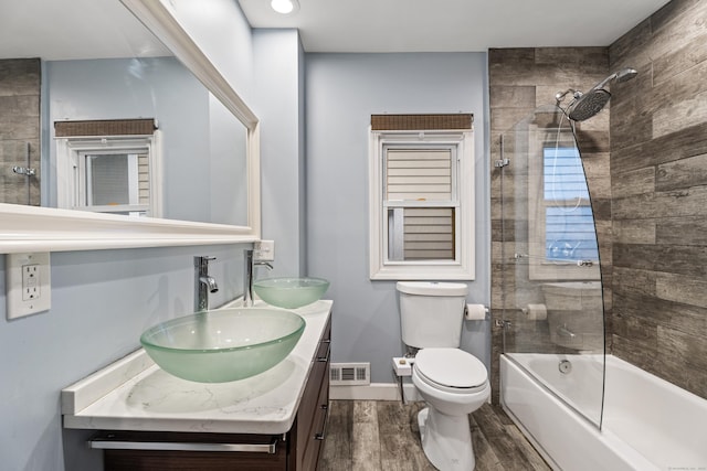 128 Mill River St, New Haven, CT 06511 - full bath with wood finished floors, double vanity, washtub / shower combination, toilet, and baseboards