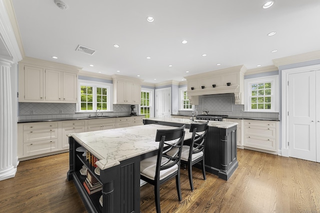 47 Ridgecrest Rd, Stamford, CT 06903 - kitchen with open shelves, a sink, a center island with sink, crown molding, and backsplash
