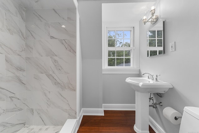47 Ridgecrest Rd, Stamford, CT 06903 - bathroom featuring a tile shower, toilet, wood finished floors, and baseboards